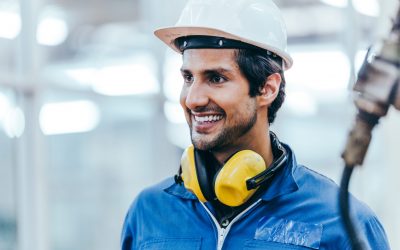Portrait of smart handsome industrial engineer worker wearing safety helmet and uniform in modern technology industry manufacturing factory. happy positive man back to work from lockdown. copy space